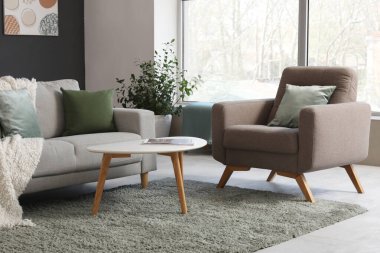 Şık oturma odasında rahat bir kanepe, koltuk ve kahve masası.