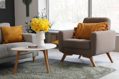 Gri kanepe, koltuk, ekose ve sehpa şık oturma odasında.