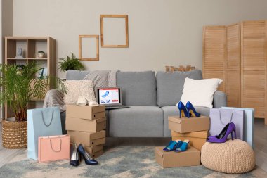 Online mağazadan yeni ayakkabılar ve oturma odasının iç kısmında dizüstü bilgisayar.