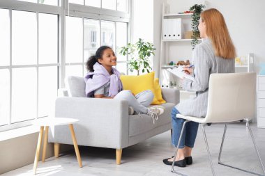 Afro-Amerikalı kız ofiste psikologla konuşuyor.