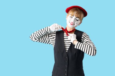 Mavi arka planda kadın pandomimist