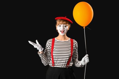 Siyah arka planda balonu olan kadın pandomimist.