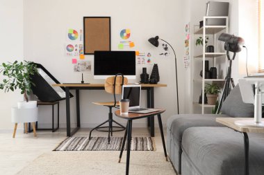 Çalışma yeri, modern bilgisayar, kanepe ve fotoğrafçı aletleri olan şık bir ofis.