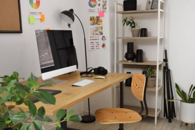 İş yeri, modern bilgisayar ve fotoğrafçı aletleri olan güzel bir ofis.