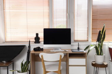 İş yeri, modern bilgisayar ve fotoğrafçı aletleri olan güzel bir ofis.