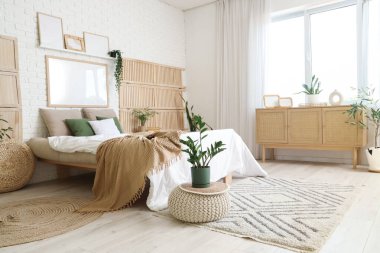 Yatak odasının içi, rahat yatak odası, puf, ev bitkileri ve halı.