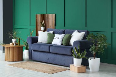 Kanepe, yuvarlak masa ve oturma odasının içindeki farklı bitkiler.