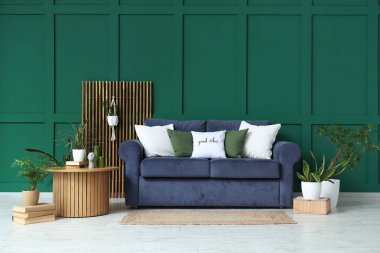 Kanepe, yuvarlak masa ve oturma odasının içindeki farklı bitkiler.