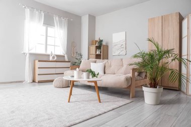 Oturma odasının içinde kanepe, masa ve dolap var.