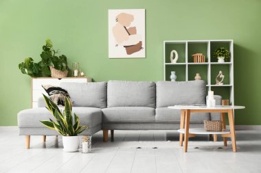 Farklı mumları ve çiçekleri olan şık bir oturma odası.