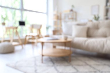 Kanepesi ve masası bulanık, modern aydınlık oturma odasının içi.