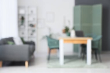 Masa, kanepe ve katlanan ekran ile aydınlık yemek odasını bulanık görmek