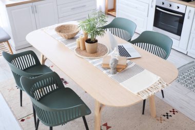 Kitaplar, mumlar ve modern dizüstü bilgisayarlar yemek odasında.