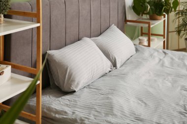 Evdeki odasında temiz yatak ve raf ünitesi olan modern bir yatak. Yakın plan.