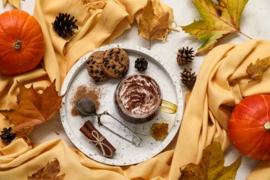 Beyaz arkaplanda bir fincan kakao, tepsi ve eşarp ile sonbahar kompozisyonu