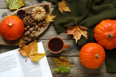 Ahşap zemin üzerinde kakao, balkabağı ve süveter dolu sonbahar kompozisyonu