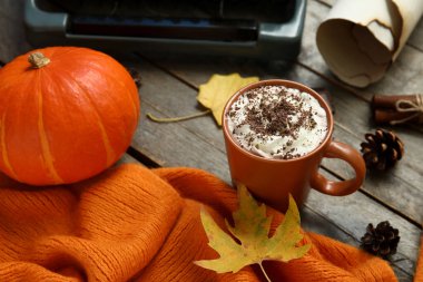 Ahşap zemin üzerinde kakao, balkabağı ve eşarp dolu sonbahar kompozisyonu