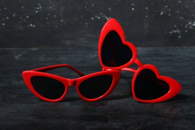 Siyah grunge arka planında şık kırmızı güneş gözlükleri