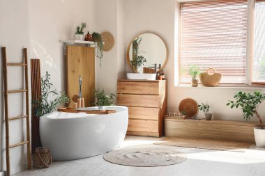 Lavabosu, küveti, çekmecesi ve aynası olan şık bir banyo.