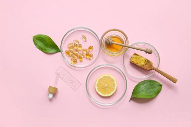 Pembe arka planda doğal kozmetik ürünleri hazırlamak için numune ve malzeme içeren petri kapları