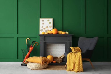 Siyah şöminesi, koltuğu, kanepesi ve balkabağı olan şık bir oturma odası. Sonbahar konsepti