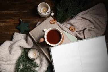 Kitaplı güzel kompozisyon, kış dekoru, sıcak süveter ve kahverengi ahşap arka planda bir fincan kakao.