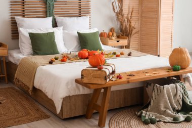 Şık yatak odasının sonbahar iç kısımları, balkabakları ve bavullarıyla.