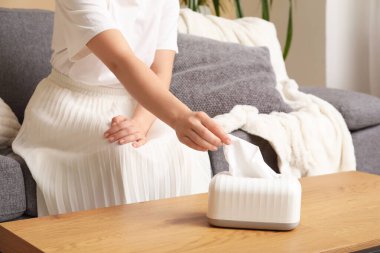 Odadaki sehpanın üzerindeki seramik tutucudan doku alan kadın.