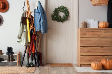 Koridorun içinde kapı, balkabağı ve askılık var.