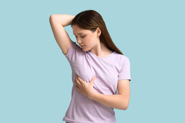 Young woman checking her breast  on blue background
