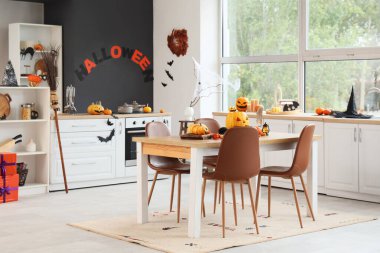 Cadılar Bayramı için mutfak içi yemek masası ve balkabağıyla dekore edilmiş.