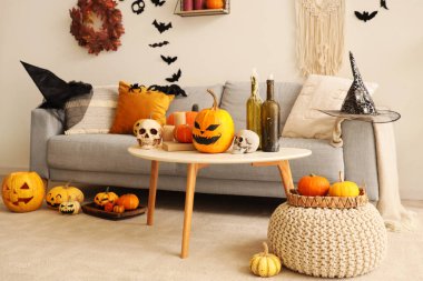 Cadılar Bayramı için dekore edilmiş oturma odasının içi kanepe, masa ve balkabaklarıyla dolu.