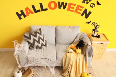 Cadılar Bayramı için kanepe, sepet ve balkabaklarıyla dekore edilmiş oturma odasının içi.