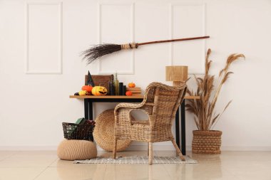 Cadılar Bayramı için masa, balkabağı ve cadı süpürgesi ile dekore edilmiş bir oda.