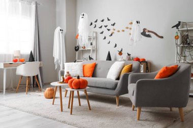 Cadılar Bayramı için dekore edilmiş oturma odasının içi kanepe, koltuk ve hayaletlerle dolu.