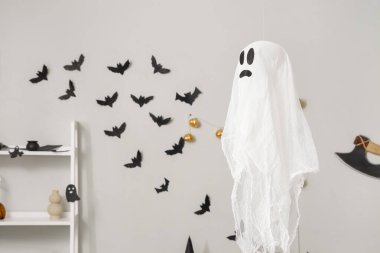 Cadılar Bayramı için dekore edilmiş aydınlık odada asılı duran hayalet.