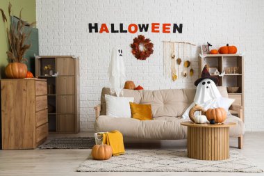 Cadılar Bayramı için dekore edilmiş oturma odasının içi kanepe, masa ve hayaletlerle dolu.