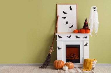 Cadılar Bayramı için dekore edilmiş odanın içinde hayalet, şömine ve cadı süpürgesi var.