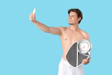 Mavi arka plandaki genç adam. Kilo verme konsepti