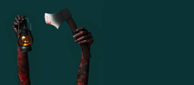 Yeşil arka planda el feneri ve balta tutan zombi elleri ve mesaj için yer var. Cadılar Bayramı