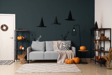 Cadılar Bayramı için dekore edilmiş oturma odasının içi kanepe ve raf üniteleriyle dolu.