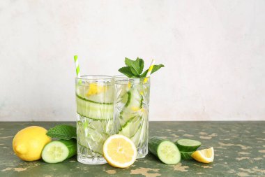 Yeşil masada salatalıklı limonata ve nane şekeri.