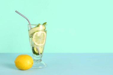 Mavi arka planda bir bardak salatalıklı limonata ve nane şekeri.
