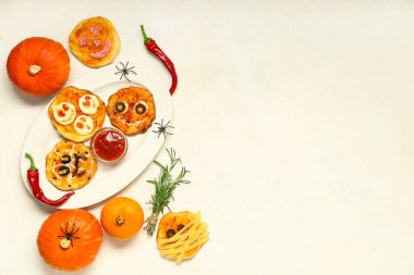 Farklı tatlı Cadılar Bayramı pizzaları ve hafif arkaplanda sos içeren kompozisyon