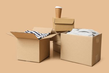 Elbise ve bej arka planda bir fincan kahve olan gardırop kutuları.