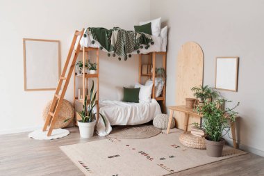 İçinde ranza ve bitkiler olan hafif çocuk odası.