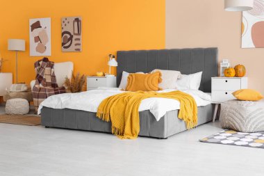 Yatak odasının içi büyük yataklı, komodinli, koltuklu ve balkabaklı.