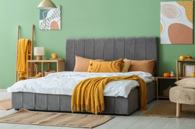 Büyük yataklı, raf üniteli, merdiven ve balkabaklı şık bir yatak odası.