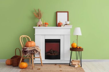 Odanın içinde şömine, balkabağı ve sandalye var.