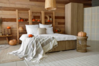 Yatak odası, raf ünitesi ve balkabaklarıyla bulanık bir manzara.